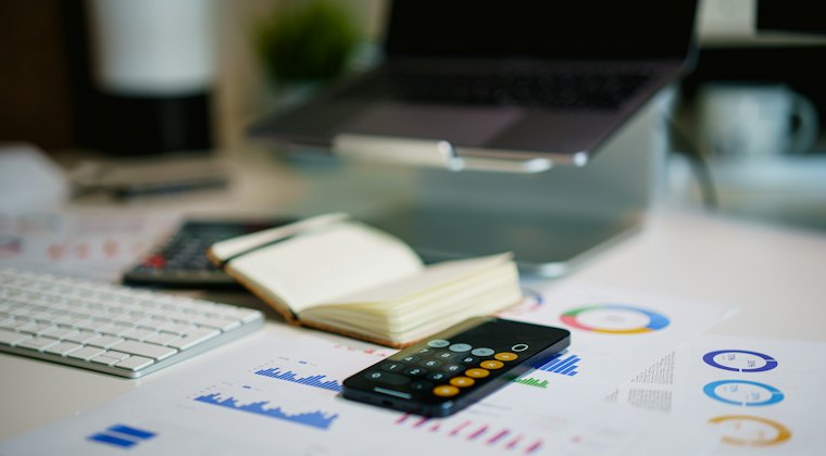 Mesa com gráficos financeiros e calculadora