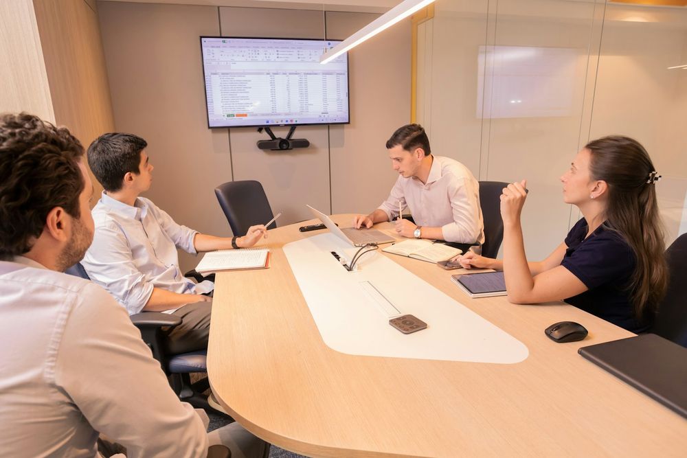 Equipe reunida em torno de uma mesa conversando