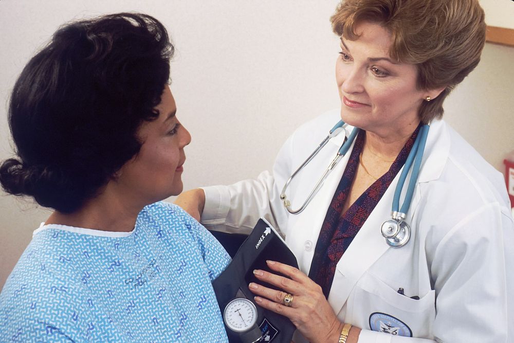 Médica medindo a pressão arterial de uma paciente