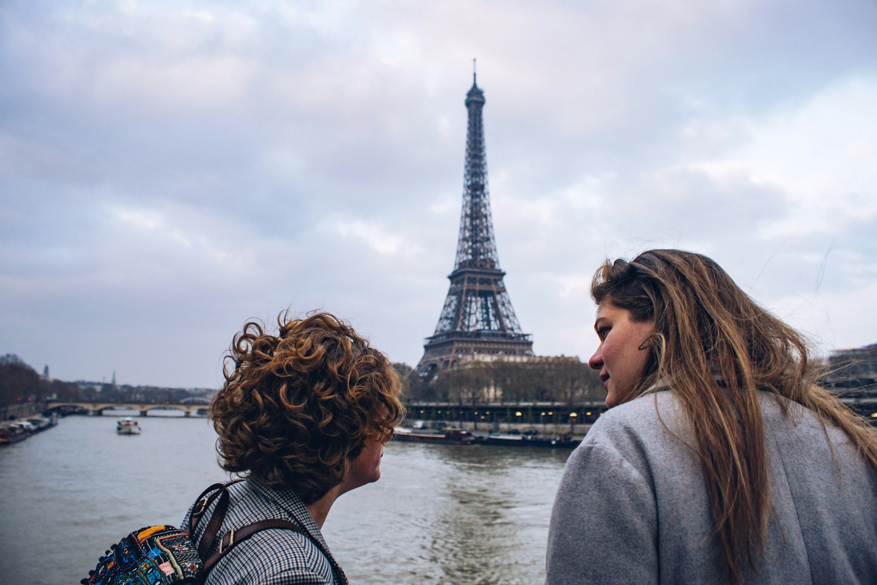 Pessoas conversando felizes com a Torre Eiffel ao fundo