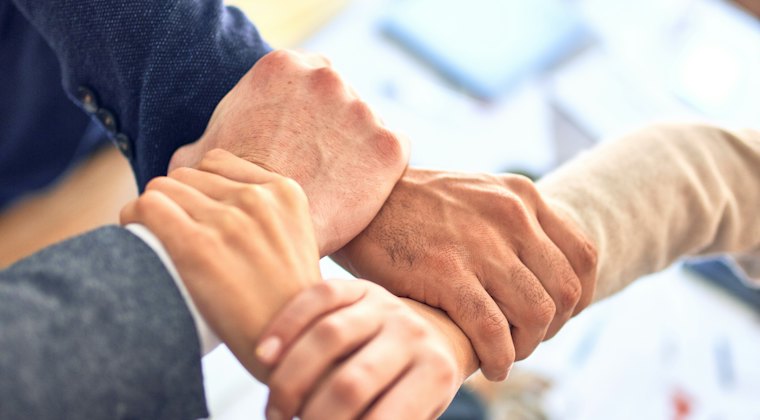 Mãos unidas representando trabalho em equipe